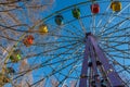 A group of colorful blue, green, red, yellow cabs of Ferris wheel in the park