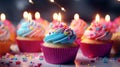 A group of colorful cupcakes with lit candles, ready for a celebration