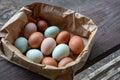 Group of Colorful Farm Fresh Eggs in a Brown Paper Bag