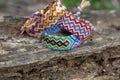 Group of colorful handmade homemade natural woven bracelets of friendship on old wood background, checkered patterns Royalty Free Stock Photo