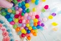 Group of colorful helium balloons stuck on a white ceiling