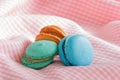 Group of colorful macaroons on pink cloth.