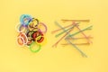 Group of Colorful mini rubber bands soft elastic bands for hair and colorful pastel color hair clips on yellow background. Royalty Free Stock Photo