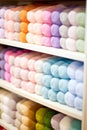 Group of colorful skeins of yarn arranged on a white shelf. AI-generated. Royalty Free Stock Photo