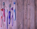 Colorful toothbrushes on a wooden background. Royalty Free Stock Photo