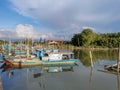 Group of colourful wooden traditional fishing boats parked on old pier fishing village, reflection of fishing boats, mangrove fore