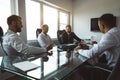 A group of company employees sits at a table in a meeting room. A team of young businessmen working and communicating Royalty Free Stock Photo