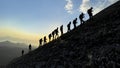 Group of compatible friends climbers hiking to the summit at sunrise