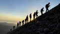 Group of compatible friends climbers hiking to the summit at sunrise