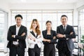 A group of confident Asian businessmen and businesswomen colleagues standing in the office and looking at the camera. Unity and Royalty Free Stock Photo