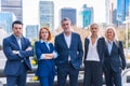 Group of confident business professionals posing in front of a modern building