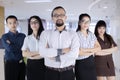 Group of confident five business people with businessman leader at front