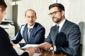 Group of confident successful business people reviewing and signing a contract to seal the deal at business meeting in Royalty Free Stock Photo