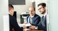 Group of confident successful business people reviewing and signing a contract to seal the deal at business meeting in Royalty Free Stock Photo