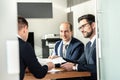 Group of confident successful business people reviewing and signing a contract to seal the deal at business meeting in Royalty Free Stock Photo