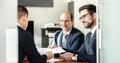 Group of confident successful business people reviewing and signing a contract to seal the deal at business meeting in Royalty Free Stock Photo