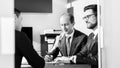 Group of confident successful business people reviewing and signing a contract to seal the deal at business meeting in Royalty Free Stock Photo