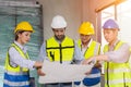 Group of construction worker team working together discussion looking floor plan at construction site planning build process Royalty Free Stock Photo