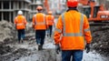 A group of construction workers navigates a muddy road, showcasing their teamwork and resilience in challenging Royalty Free Stock Photo