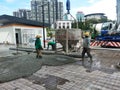 Group of construction workers pouring wet concrete using the mobile crane bucket the construction site. Royalty Free Stock Photo
