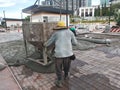 Group of construction workers pouring wet concrete using the mobile crane bucket the construction site. Royalty Free Stock Photo