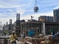 Group of construction workers pouring wet concrete using the mobile crane bucket the construction site. Royalty Free Stock Photo