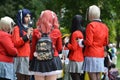Group of cosplaying girls in red manga school uniforms at public park called `Friedrichsplatz` in Mannheim during anual anime conv