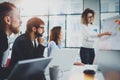 Group of coworkers working together on new business presentation at sunny meeting room.Horizontal.Blurred background. Royalty Free Stock Photo