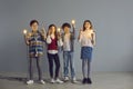 Group of creative clever kids holding shining light bulbs and pointing fingers up Royalty Free Stock Photo