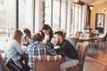 Group of creative multietnic friends sitting at wooden table. People having fun while playing board game