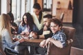 Group of creative multietnic friends sitting at wooden table. People having fun while playing board game