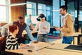 Group of creative professionals collaborating in a modern office using virtual reality headset and digital devices Royalty Free Stock Photo