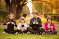 Group of curious kids using mobile phone device together. Telephone addiction. Royalty Free Stock Photo