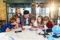 Group of curious school children listen their Korean male teacher uses device of tablet computer for show educational