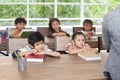 group of cute happy little child student leaning on table with book in classroom elementary school . kid clever sitting at desk Royalty Free Stock Photo