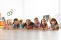 Group of cute little children lying on floor. Kindergarten playtime activities Royalty Free Stock Photo