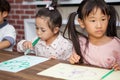 group of Cute little girl and boy student blowing color pen painting together with nursery teacher in classroom school . Happy