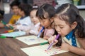 group of Cute little girl and boy student blowing color pen painting together with nursery teacher in classroom school . Happy
