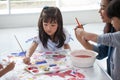 group of Cute little girl student painting  together with nursery teacher in classroom school . Happy children in a kindergarten Royalty Free Stock Photo