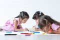 Group of cute little kids girls have fun drawing on paper while sitting and lying on the floor. Adorable happy diversity children Royalty Free Stock Photo