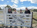 Group cyclists on Central Otago Rail Trail leaning on gate and sign at rest stop