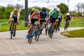 several men wearing bicyclists are on bicycles near the road