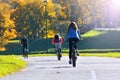 A group of cyclists moves along the autumn street