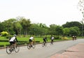 A group of cyclists ride in a park on a bicycle