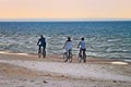 Group of cyclists riding bicycles along the seaside in the evening. Royalty Free Stock Photo