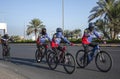 Group of cyclists riding bicycles on an empty street wearing face masks Royalty Free Stock Photo