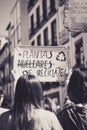 Group of demonstrators holding protest signs on a bustling street on a daylight rally in grayscale