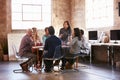 Group Of Designers Having Meeting Around Table In Office Royalty Free Stock Photo