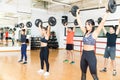 Determined Men And Women Lifting Barbells In Gym