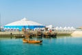 A group of dhows, traditional boats of Bahrain, are anchoring in front of a white tent...IMAGE